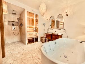a bathroom with a tub and a shower and a sink at SEIN Boutique Suites - ADULTS ONLY in Gosau