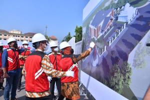 a group of people in hard hats painting a wall at Bank Amar in Jakarta