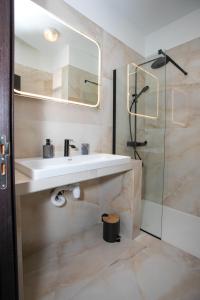 a bathroom with a sink and a glass shower at Palmove Renovated Meneou House in Larnaka