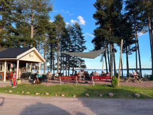VåmhusVåmåbadets Camping的一群人坐在靠近水面的长椅上