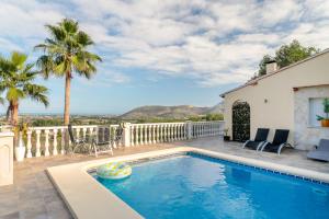 a swimming pool on a patio with a house at Appartement villa Mariposa in Casas Albardanera