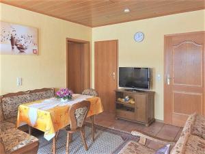 a living room with a table and a tv at Haus Sonnenblick in Fischbach bei Dahn