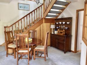 a dining room with a table and a staircase at The Coach House in Saint Fillans +34 photos