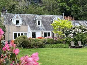 セント・フィルカンズにあるThe Coach Houseのピンクの花の庭のある家