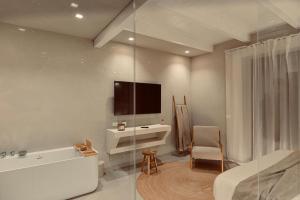 a bathroom with a tub and a tv on the wall at Palermo Inn Boutique Arte in Palermo