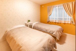 前橋市にあるGUMPAKU Maebashi - Vacation STAY 81491vの窓のある部屋にベッドが2つある