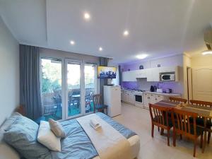 a bedroom with a large bed and a kitchen at Balcony Apartman Szeged in Szeged