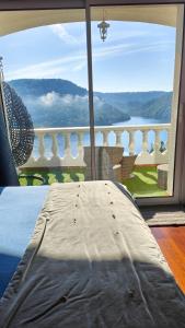 un lit devant une grande fenêtre avec vue dans l'établissement Ma villa au bord de l'eau, à Miremont