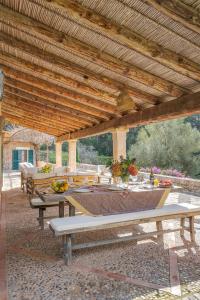 a patio with picnic tables and a wooden roof at La Zalema in Esporles