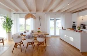 KrumminFerienhäuser Ankerplatz 1 und 2 Usedom mit Sauna, Kamin und Garten的厨房兼餐厅，配有桌椅 更多35张照片