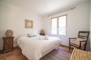 a bedroom with a large white bed and a chair at Nouveau ! Maison familiale à 100m de la plage in Saint-Trojan-les-Bains