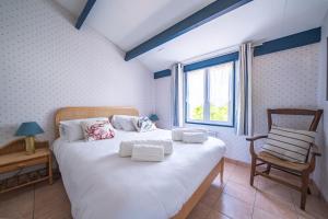 a bedroom with a bed with a chair and a window at Nouveau ! Maison familiale à 100m de la plage in Saint-Trojan-les-Bains