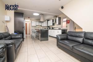 a living room with a couch and a kitchen at Kunda House Dawlish in Birmingham