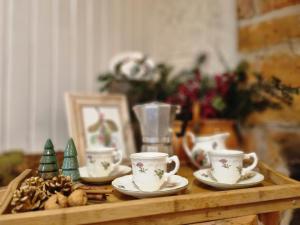 拉普斯尼恩Miodowa Chata的一张木桌,上面有杯子和碟子