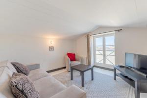 ein Wohnzimmer mit Sofa und Fernseher in der Unterkunft Maison de village L'A N N E X E proche du port in Saint-Martin-de-Ré