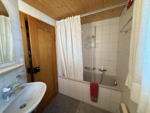 a bathroom with a sink and a shower and a tub at Revier mon désir in Braunwald +10 photos