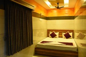 a bedroom with a bed and a ceiling fan at Vendha Sea Park in Velankanni +21 photos