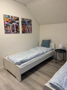 a bedroom with two beds and two paintings on the wall at Wohlfühloase am Tor zur Hamburg in Uetersen