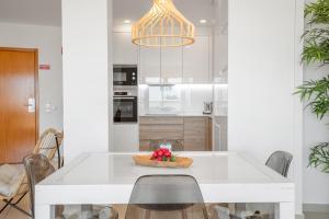 een keuken met een witte tafel en een schaal fruit bij Orange Beach Ocean View, Porto de Mós VR29 in Lagos
