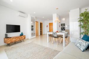 een woonkamer met een eettafel en een tv bij Orange Beach Ocean View, Porto de Mós VR29 in Lagos