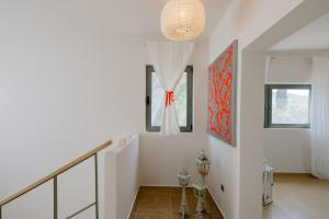 a white staircase in a home with a red painting at Caza Bella Vista a Luxurious House in Kos Town +49 photos