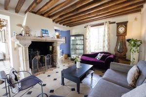 a living room with a couch and a fireplace at Domaine Chapelle in La Chapelle-la-Reine