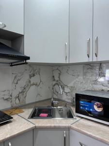a kitchen counter with a sink and a microwave at Apart otel sun and moon in Batumi +5 photos