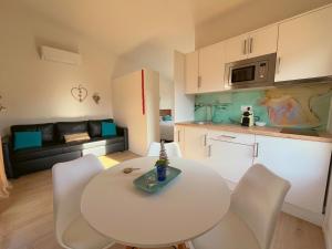 a kitchen and living room with a white table and chairs at Casas Natura Suites Graus in Graus