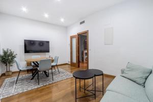 un soggiorno con un divano e un tavolo di Luxury Suite Reina Isabel a Granada