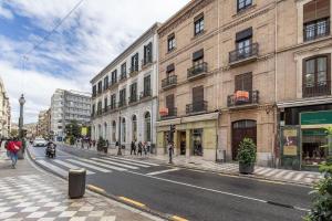 una via cittadina con edifici e persone che camminano sul marciapiede di Luxury Suite Reina Isabel a Granada Altre 5 foto