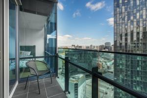 メルボルンにある37th Floor City Views Luxury Apartment and Parkingの市街の景色を望むバルコニー(椅子付)