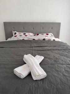 a bed with two white towels on top of it at Stan na dan GlobusMG in Mrkonjić Grad