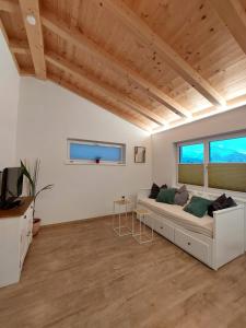 a living room with a couch and two windows at Ferienwohnung Zimmerle in Pflach