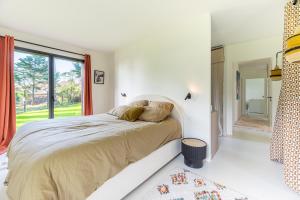 Un dormitorio con una cama grande y una ventana en La Cabane des Vagues à Préfailles, en Préfailles