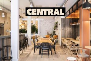 波尔多CENTRAL Hostel Bordeaux Centre的一家餐厅，摆放着桌椅，招牌上写着“中心”。