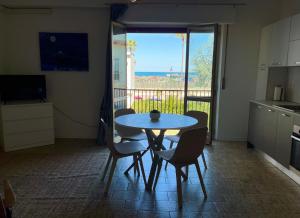 a table and chairs in a room with a balcony at La Casa Sul Pontile in Vasto