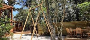 a patio with a table and chairs and trees at ZEcamping 3 étoiles animaux acceptés piscine et aire de jeux in Porto-Vecchio +15 photos