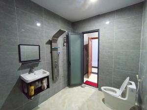 ein Badezimmer mit Waschbecken, Toilette und Dusche in der Unterkunft Hotel Tân Bình Bàu Bàng in Ấp Bàu Cỏ