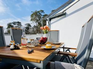 a wooden table with food and fruit on a balcony at Ferienwohnung Ostseewind 10 Parkvillen Carlota und Candela Baabe in Baabe