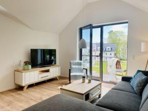a living room with a couch and a tv at Ferienwohnung Ostseewind 10 Parkvillen Carlota und Candela Baabe in Baabe