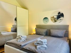 a bedroom with two beds and towels on a bed at Ferienwohnung Ostseewind 10 Parkvillen Carlota und Candela Baabe in Baabe