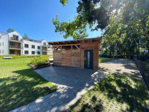 a small wooden shed with a door in a yard at Ferienwohnung Ostseewind 10 Parkvillen Carlota und Candela Baabe in Baabe