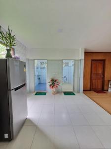a kitchen with a refrigerator and a room with a floor at Bang Yan Rimlay in Ko Yao Noi