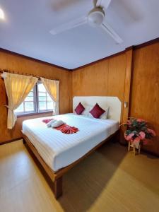 a bedroom with a large white bed with a window at Bang Yan Rimlay in Ko Yao Noi