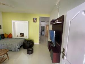 a living room with a flat screen tv and a couch at Varkala Beats - Traveller's Pad in Varkala