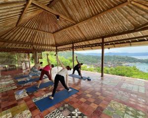 a group of people doing yoga in a pavilion at Yoga bale house in Padangbai