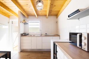 een keuken met witte kasten en een houten plafond bij Home2Book Boutique Cave Retreat, Candelaria in Candelaria