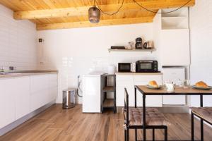 een keuken met een tafel en een keuken met witte apparatuur bij Home2Book Boutique Cave Retreat, Candelaria in Candelaria