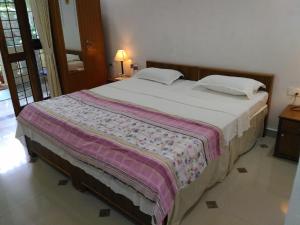 a bedroom with a large bed with at Alba Rooms Palolem Rosebuds in Palolem