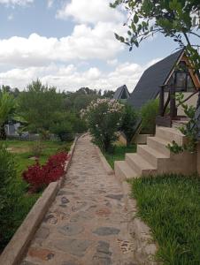 un chemin de pierres devant une maison avec des escaliers dans l'établissement Topi Cottages, à Nanyuki 46 autres photos